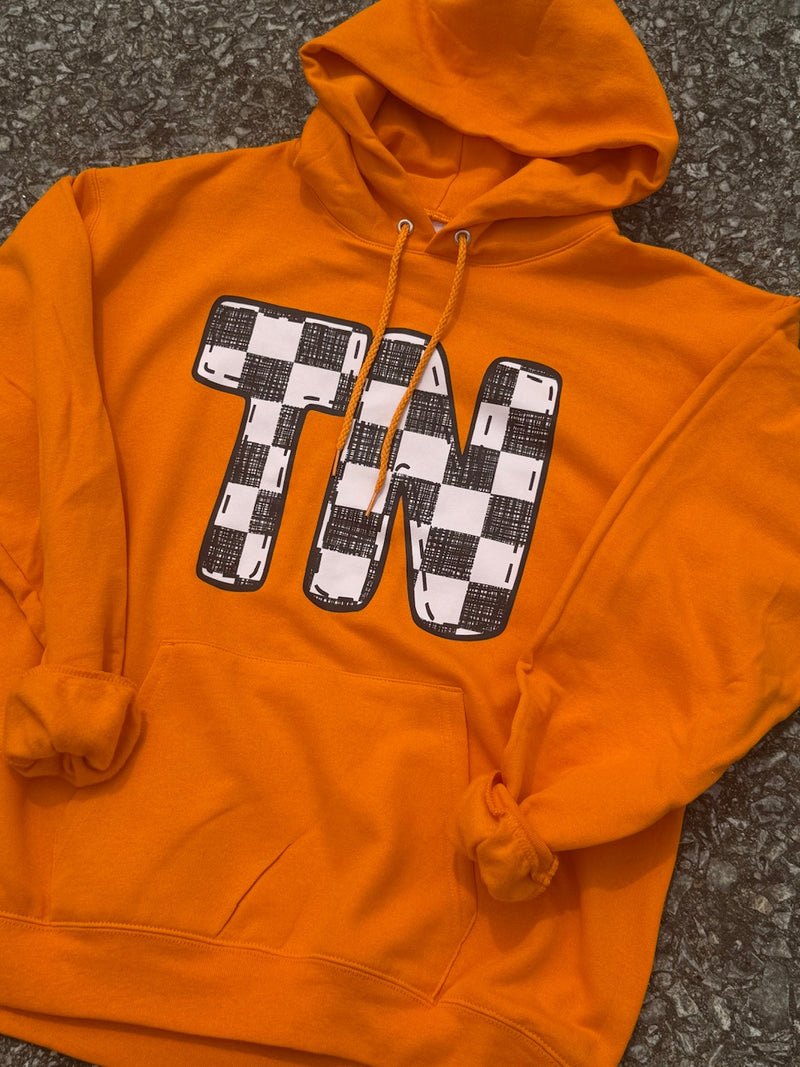 Bright Orange long sleeve hoodie with large black and white checkorboard TN graphic. Hoodie is laying on the floor