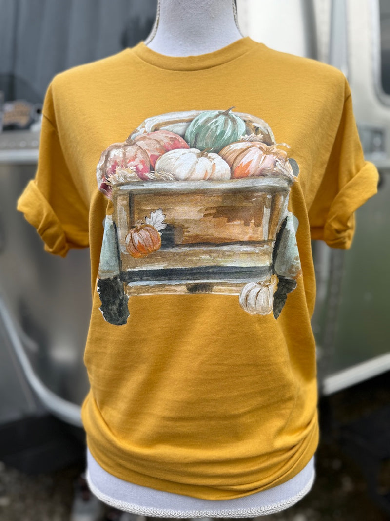 Mustard yellow t-shirt with a vintage truck hauling pumpkins graphic on a mannequin.