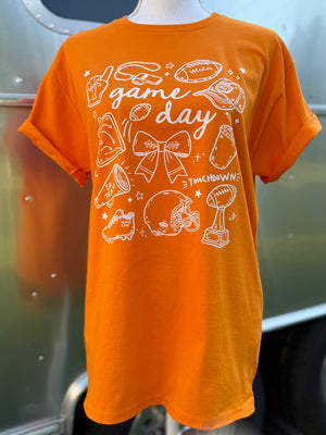 Orange t-shirt with 'game day' and sports-themed graphics in white on a mannequin.